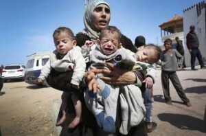 img_20240330_200524_555440541797252405228-300x198 A woman carries three babies as she reaches the central part of the Gaza Strip after fleeing the Al-Shifa hospital compound in Gaza City, on March 21, 2024.